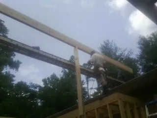 Carpenter setting a ridge beam over a new addition frame — Ice Dam Removal by Roofing Brothers in Mineral