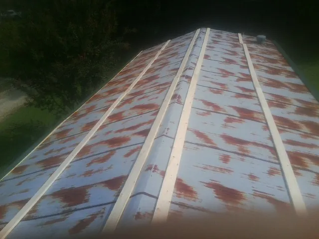 Rusted metal roof panels with new wood purlins before replacement in Mineral