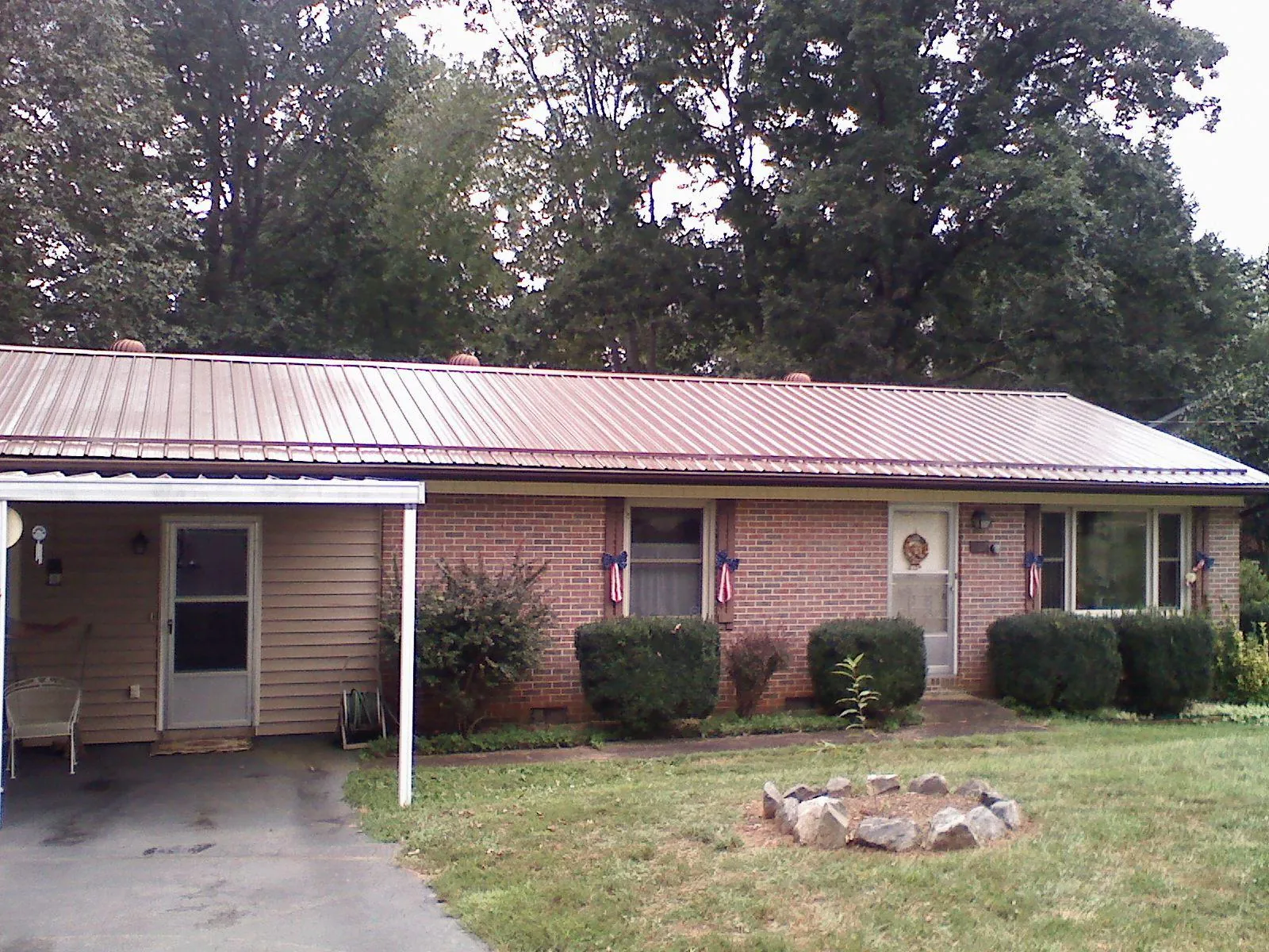 Bronze metal roof and carport on a brick ranch home — Roof Repair work by our crew in Mineral
